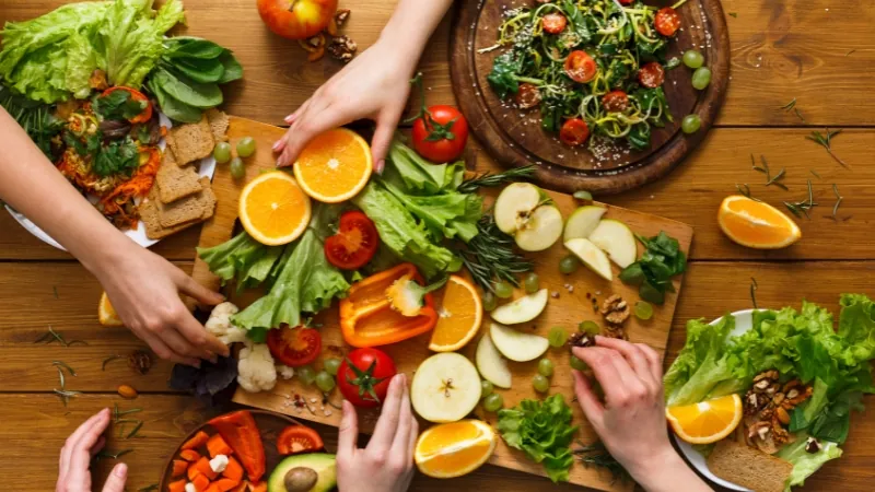 Mesa de consulta com alimentos saudáveis e caderno de anotações.