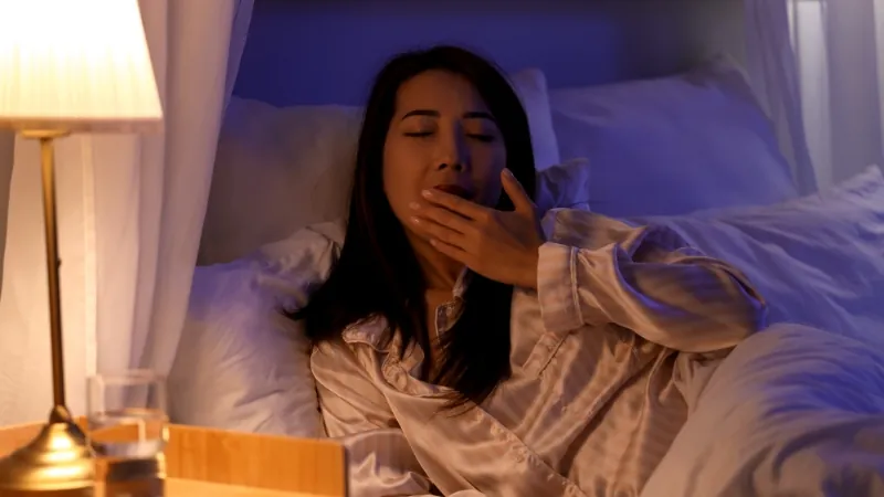 Quarto minimalista com travesseiros claros e xícara de chá.