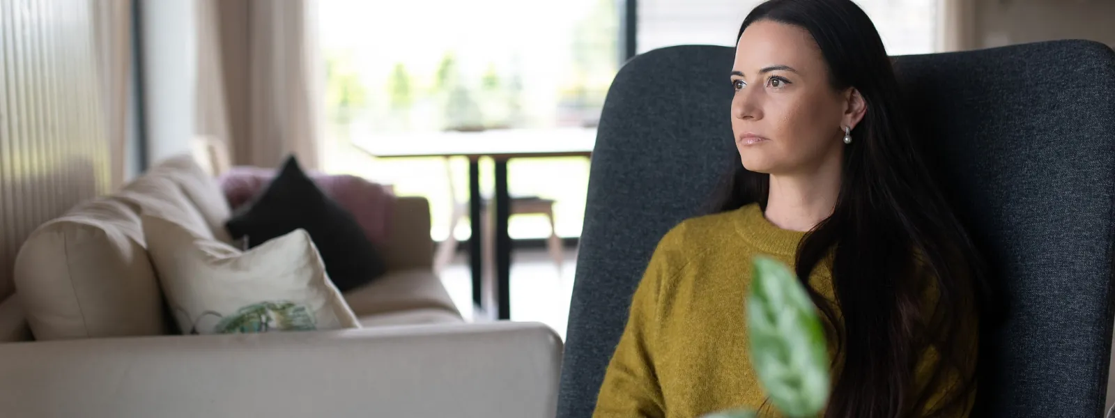 Mulher madura consultando um tablet em sala com luz natural.